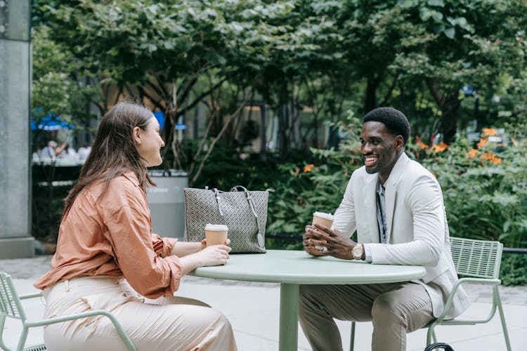 Two people having a casual business conversation at a cafe - showing how easy the partner pitch is